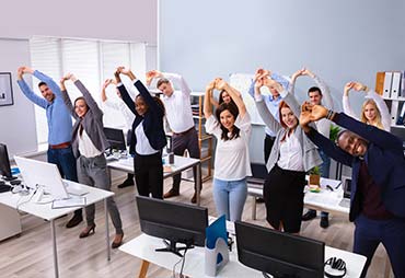 an office team stretching in office together