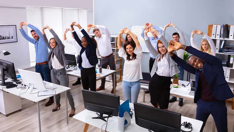 an office team stretching in office together